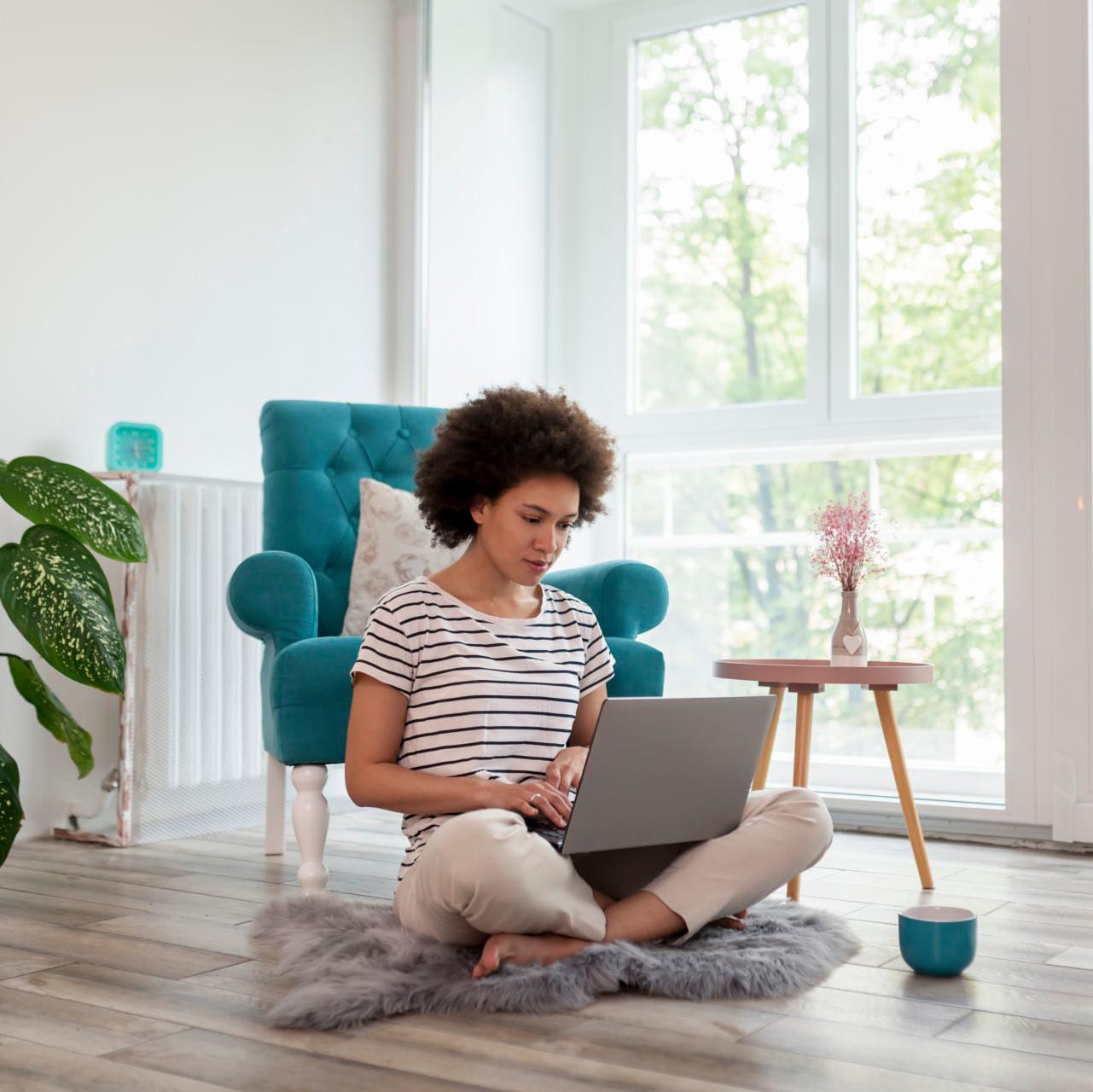 A young woman checks her accounts online after learning how a debt management plan can help her get back on track.